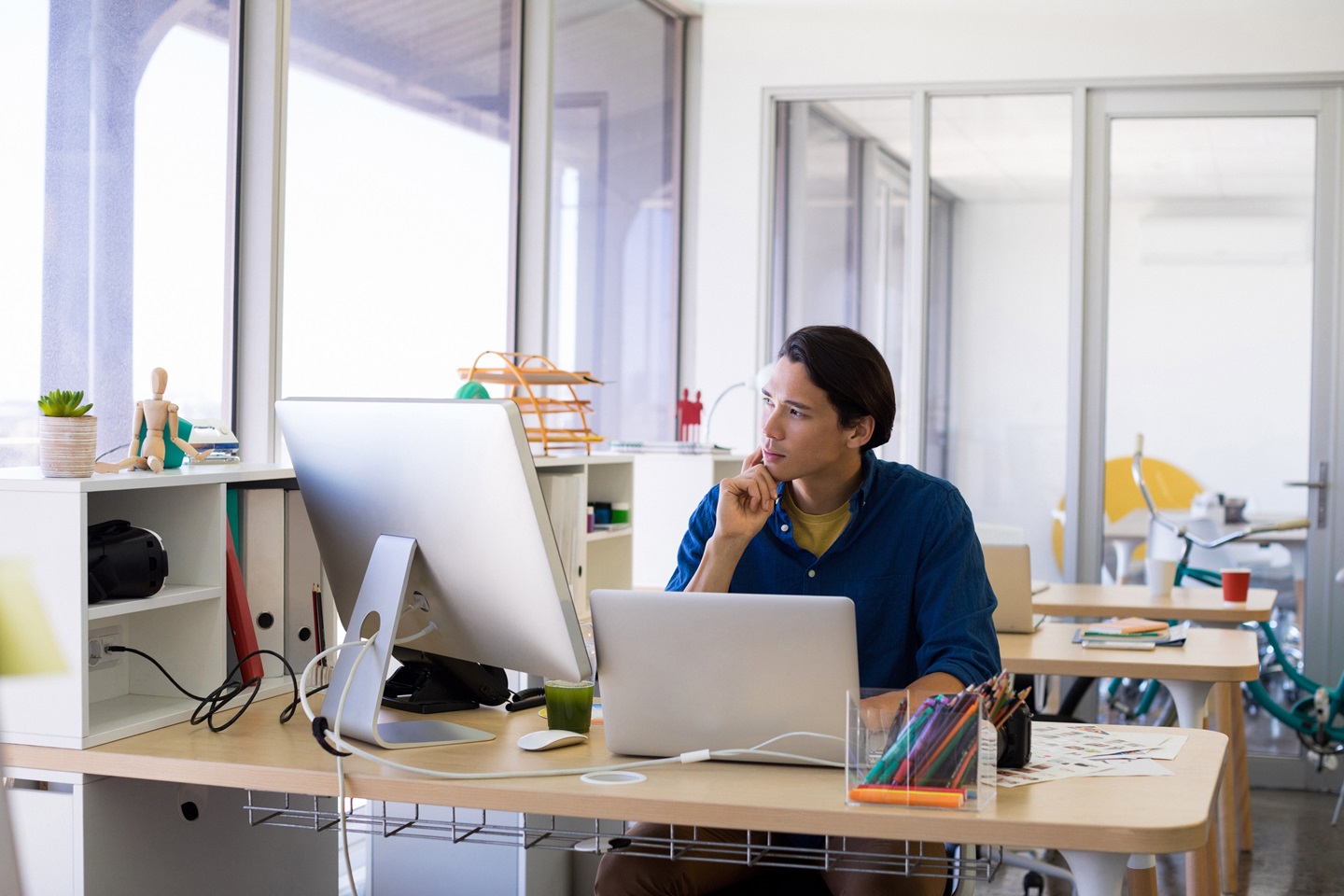 Man thinking and working over laptop at his desk